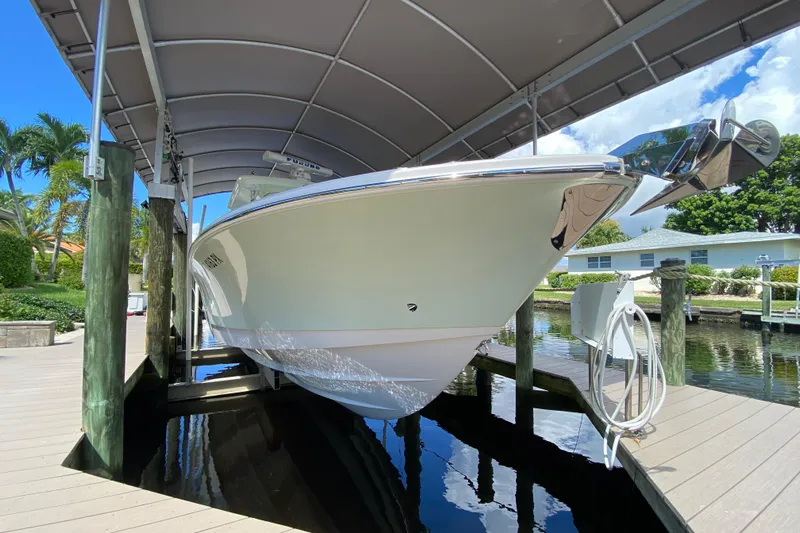 Pretty Fine Yacht Photos Pics 2015 Edgewater 320CC boat docked under canopy, surrounded by tropical scenery.