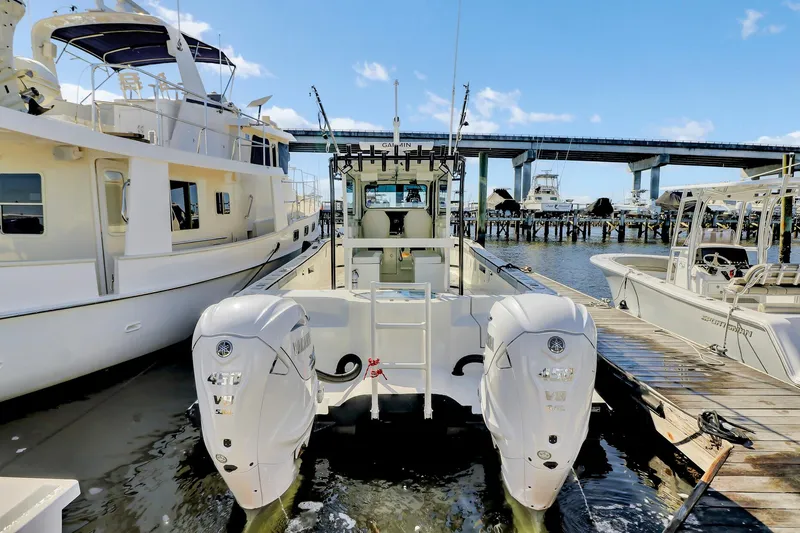 Our Trade Yacht Photos Pics Custom Nerowalker 2024 boat docked with dual outboard engines, under a clear blue sky.