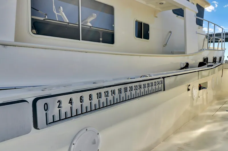 Our Trade Yacht Photos Pics Custom Nerowalker 2024 boat with measurement scale on the side, docked under clear skies.