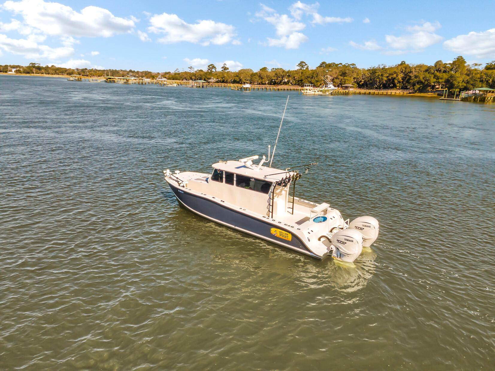 Custom 2024 Nerowalker boat cruising on a scenic river under a clear blue sky.