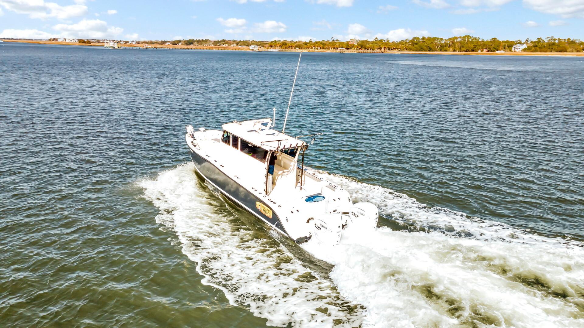 Custom Nerowalker 2024 boat cruising on a scenic waterway under a clear blue sky.