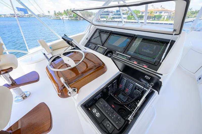 Sandbob II Yacht Photos Pics Control panel of 2021 Viking 72 Convertible yacht with steering wheel and navigation screens.