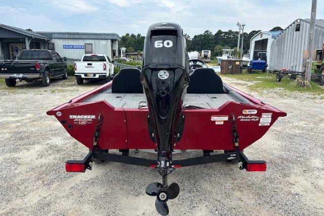 2023 Tracker Pro Team 175 TXW boat, red, rear view with 60 HP motor, parked outdoors.