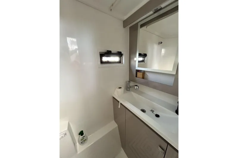  Yacht Photos Pics Modern bathroom interior of 2025 Fountaine Pajot MY4.S yacht, featuring sleek sink and mirror.