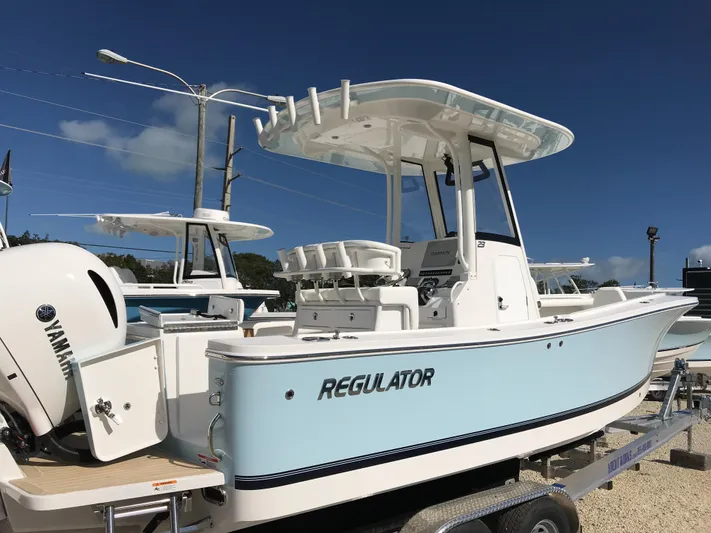 Regulator 23 Carolina Blue Yacht Photos Pics 2023 Regulator 23 boat with Yamaha engine, displayed on a trailer under clear blue sky.