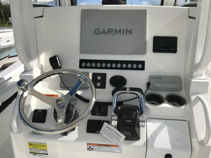 Regulator 23 Carolina Blue Yacht Photos Pics 2023 Regulator 23 boat dashboard with Garmin navigation system and steering wheel.