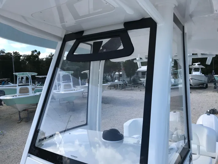 Regulator 23 Carolina Blue Yacht Photos Pics 2023 Regulator 23 boat with sleek windshield design in a marina setting.