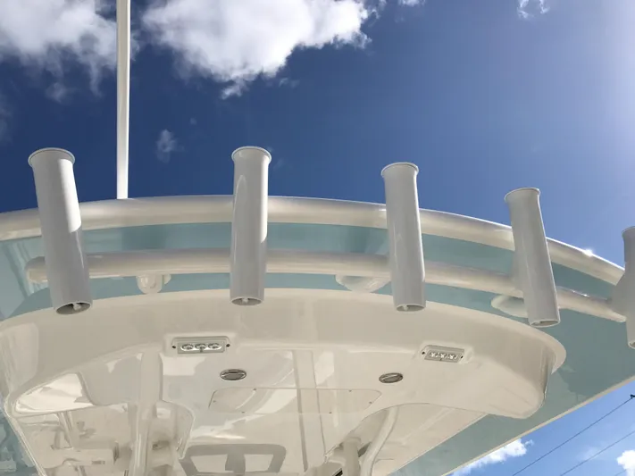 Regulator 23 Carolina Blue Yacht Photos Pics 2023 Regulator 23 boat with rod holders against a clear blue sky.