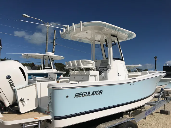 Regulator 23 Carolina Blue Yacht Photos Pics 2023 Regulator 23 boat with Yamaha engine, displayed on a trailer under clear blue sky.
