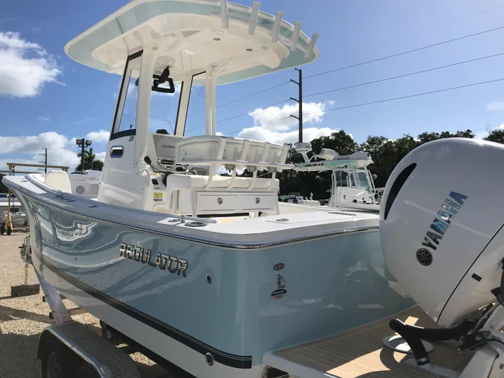 Regulator 23 Carolina Blue Yacht Photos Pics 2023 Regulator 23 boat with Yamaha engine, light blue hull, and T-top, parked outdoors.