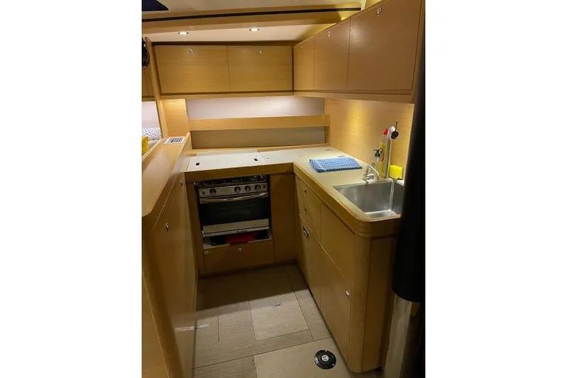  Yacht Photos Pics Modern kitchen in 2015 Dufour 560 Grand Large yacht, featuring wood cabinetry and stainless steel appliances.