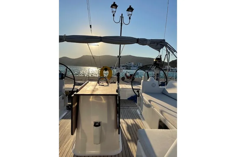  Yacht Photos Pics Dufour 560 Grand Large 2015 yacht deck at sunset, with scenic ocean view.