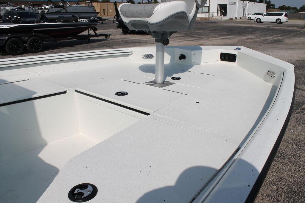 2026 Excel Bay Pro Elite 203 boat deck with seating, parked outdoors.