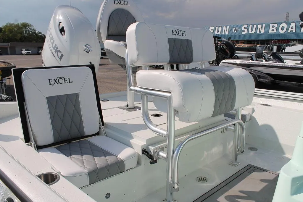 2026 Excel Bay Pro Elite 203 boat seats with Suzuki engine in a showroom.