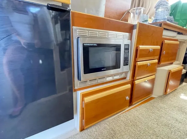 Elaine Hope Yacht Photos Pics 2017 Cutwater C-30 CB interior with microwave, fridge, and wooden cabinetry.