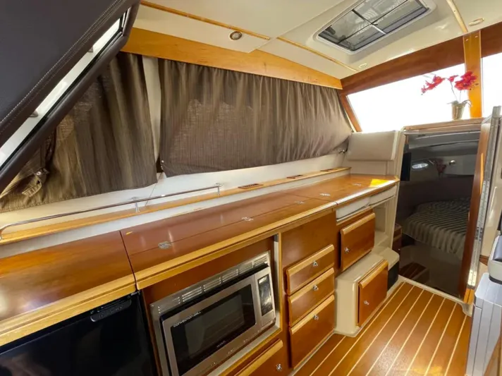 Elaine Hope Yacht Photos Pics 2017 Cutwater C-30 CB interior with wood cabinetry, microwave, and cozy sleeping area.