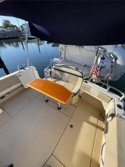 Elaine Hope Yacht Photos Pics 2017 Cutwater C-30 CB boat deck with seating and table, docked by the water.