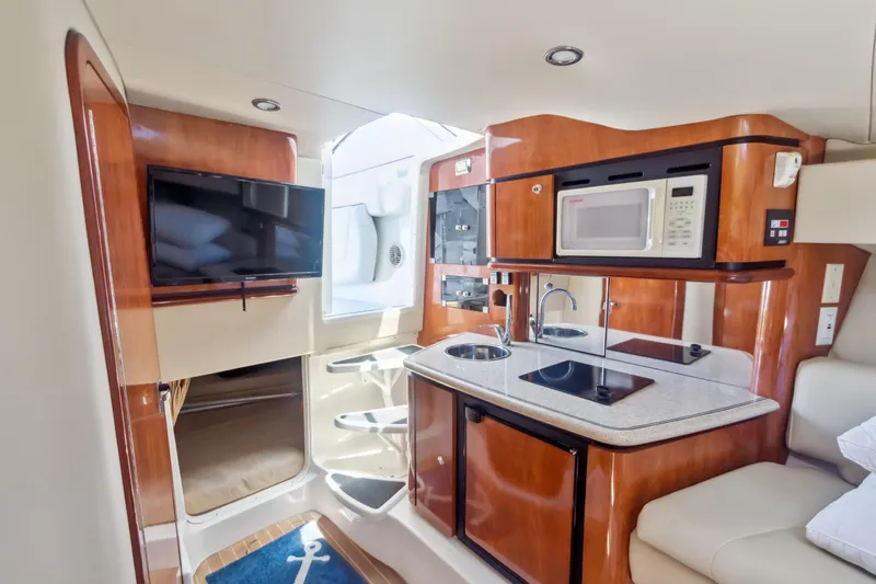 Swift Serenity Yacht Photos Pics 2008 Fountain 38 Sport Cruiser interior with kitchenette, TV, and modern amenities.