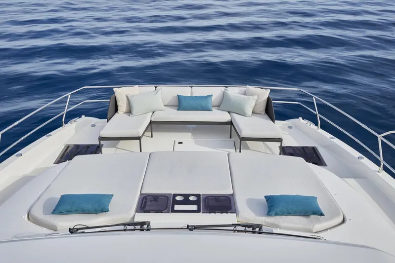  Yacht Photos Pics Prestige M48 2025 yacht with luxurious sunbathing area and cushions on calm sea.