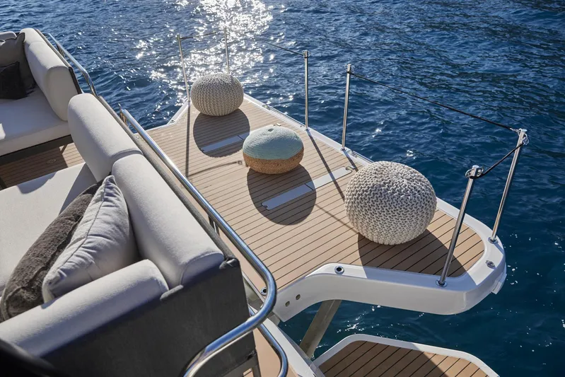 Yacht Photos Pics Prestige M48 2025 yacht deck with cushions, overlooking serene blue water.
