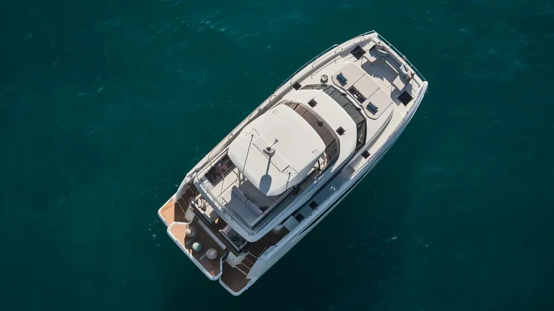 Yacht Photos Pics Aerial view of 2025 Prestige M48 yacht cruising on clear blue water.