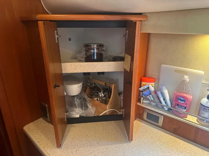Selladoor (previously "czech Mate") Yacht Photos Pics Open cabinet in 2007 Tiara Yachts 4300 Sovran, showing kitchen items and toiletries.