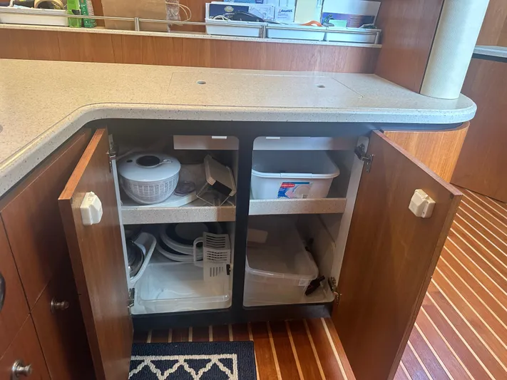 Selladoor (previously "czech Mate") Yacht Photos Pics 2007 Tiara Yachts 4300 Sovran kitchen cabinet with open doors, revealing storage items.