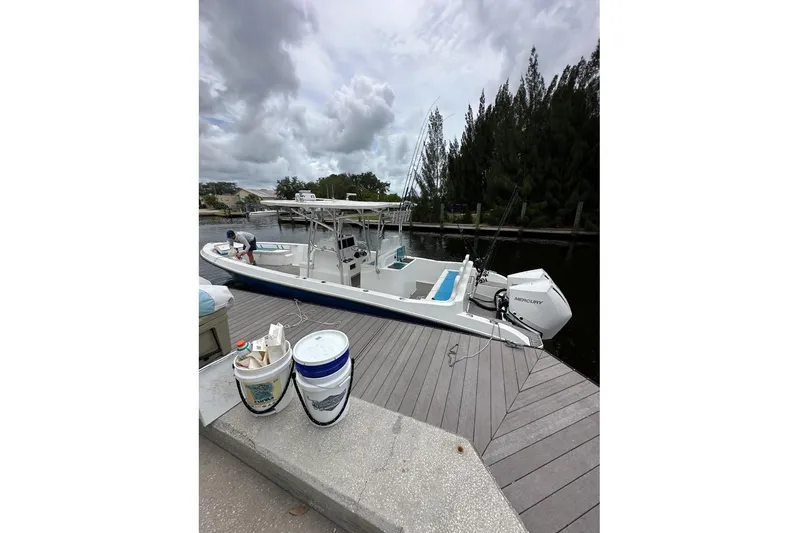  Yacht Photos Pics Custom Infusion 34 CC boat docked, 2021 model, with fishing gear and cloudy sky.