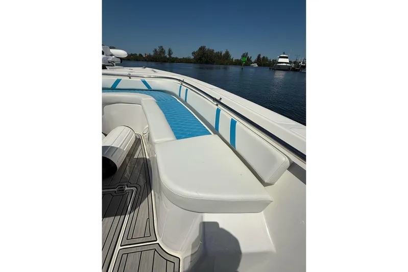  Yacht Photos Pics Custom Infusion 34 CC 2021 boat with white and blue seating, docked on a sunny day.