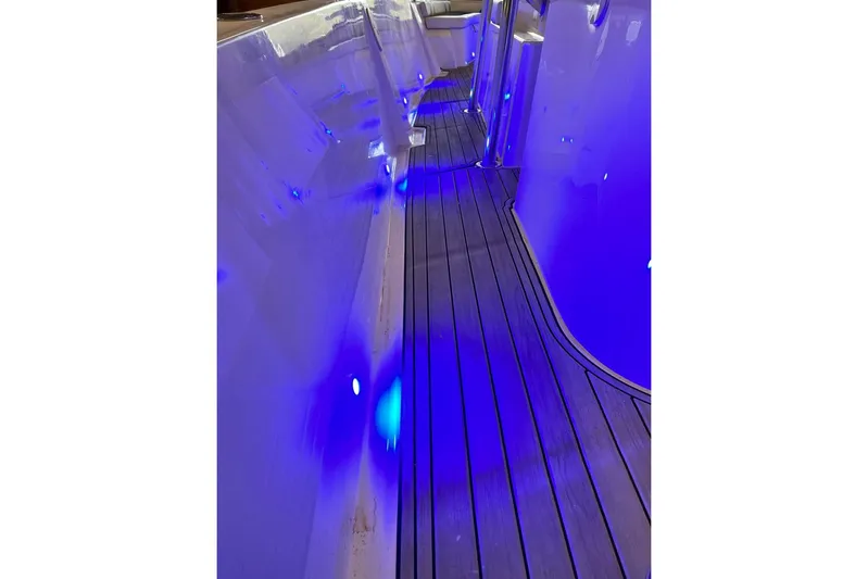  Yacht Photos Pics Custom Infusion 34 CC 2021 boat interior with blue LED lighting and sleek wooden flooring.