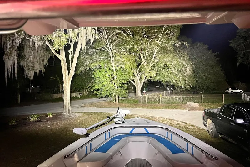  Yacht Photos Pics Custom Infusion 34 CC boat parked at night, illuminated by bright lights, with trees in the background.