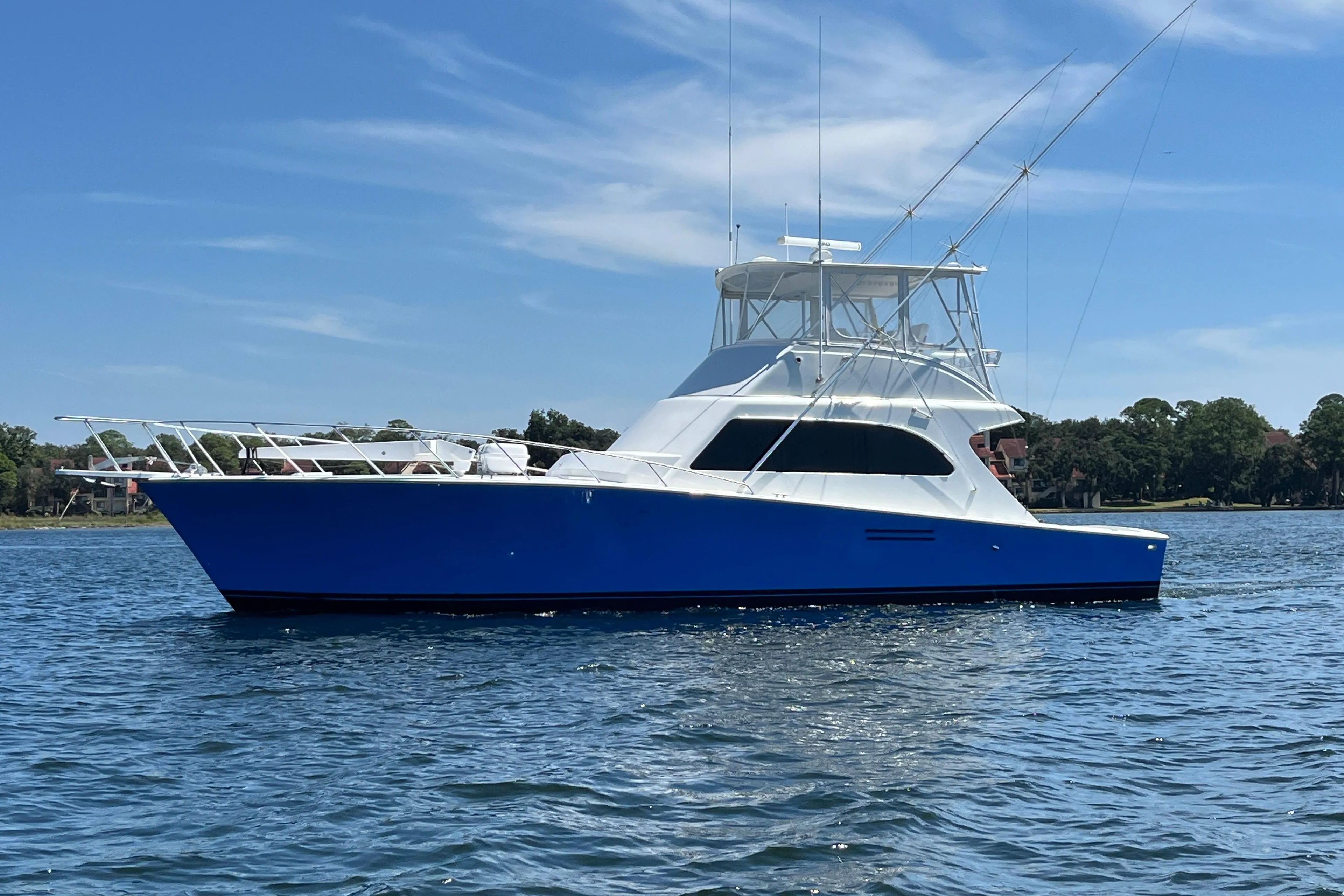 1997 Post Sportfish boat on water, blue hull, clear sky background.