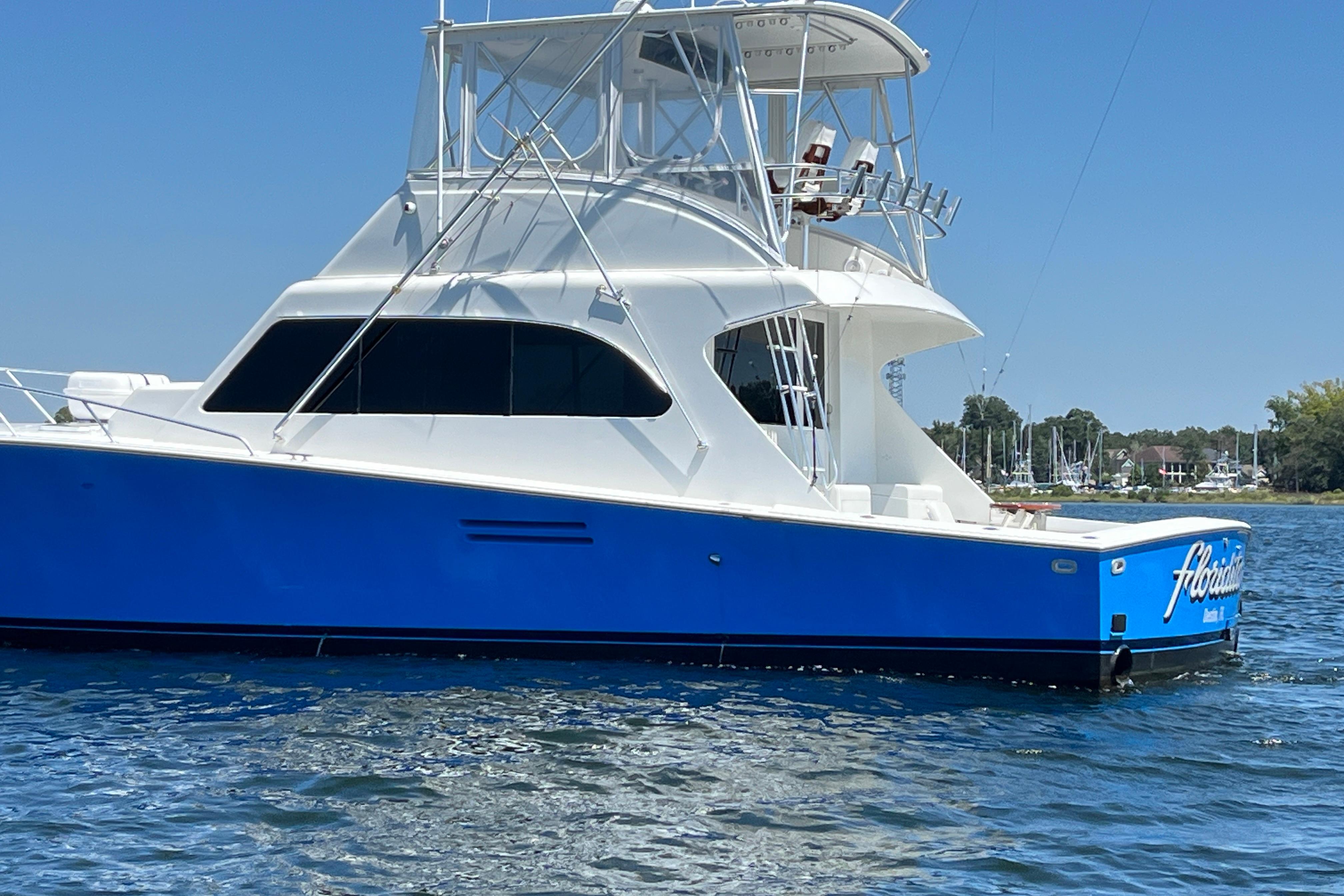 1997 Post Sportfish boat with blue hull on calm water.
