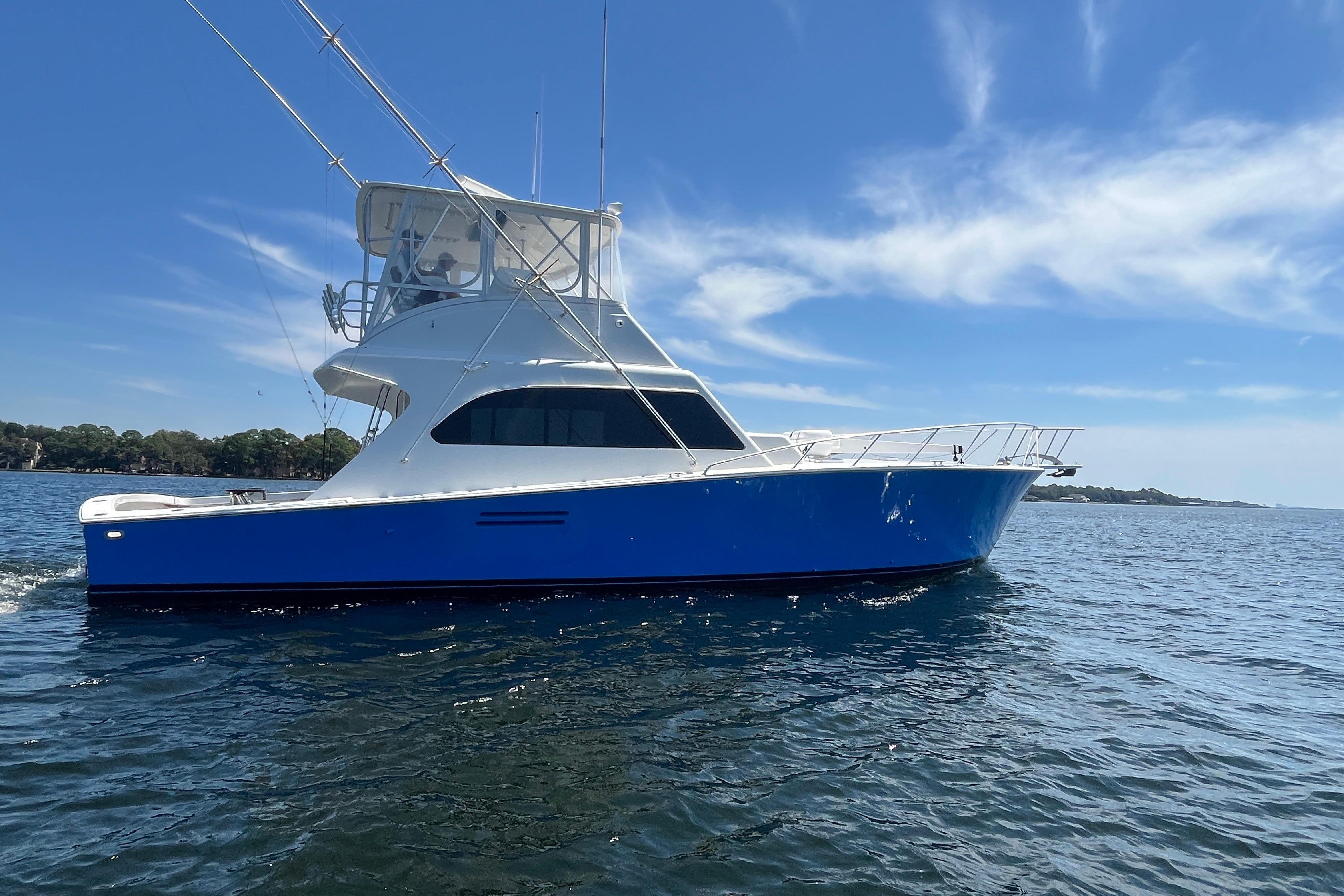 1997 Post Sportfish boat cruising on open water under a clear blue sky.
