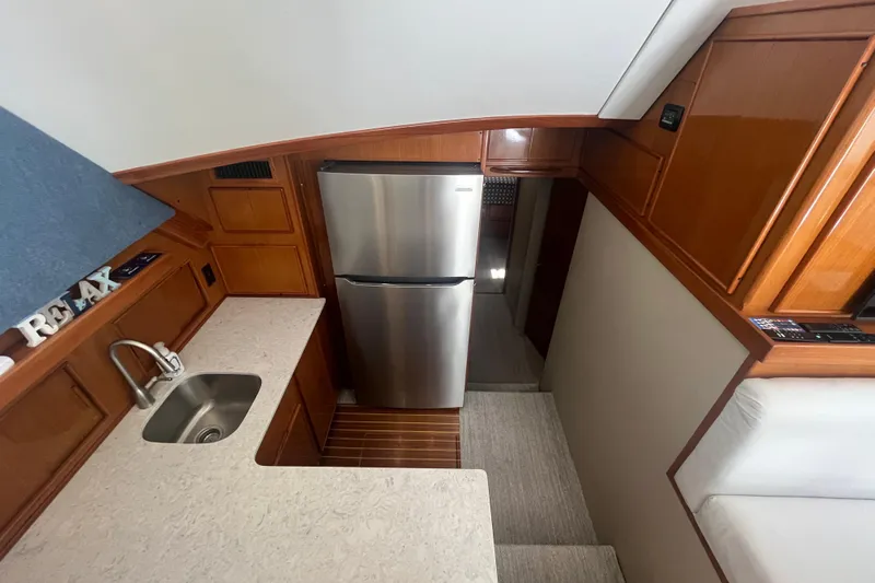 Floridita Yacht Photos Pics 1997 Post Sportfish yacht interior with kitchenette, stainless steel fridge, and wooden cabinetry.
