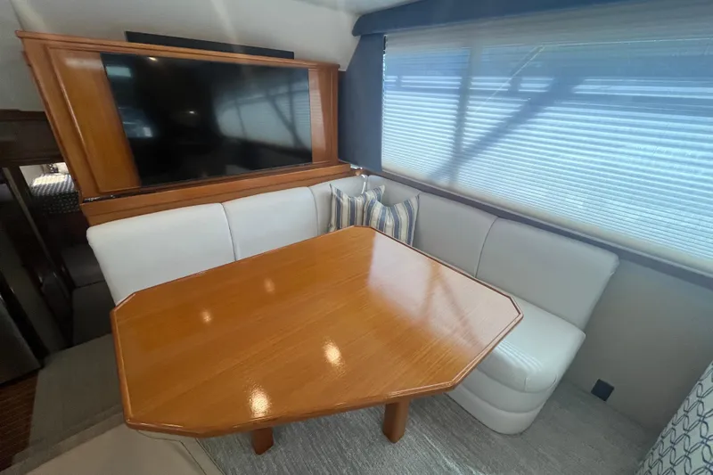Floridita Yacht Photos Pics Luxurious 1997 Post Sportfish yacht interior with wooden table and white seating.