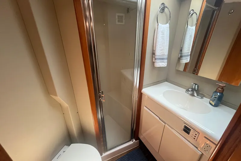 Floridita Yacht Photos Pics 1997 Post Sportfish bathroom with shower, sink, and mirror in compact marine design.