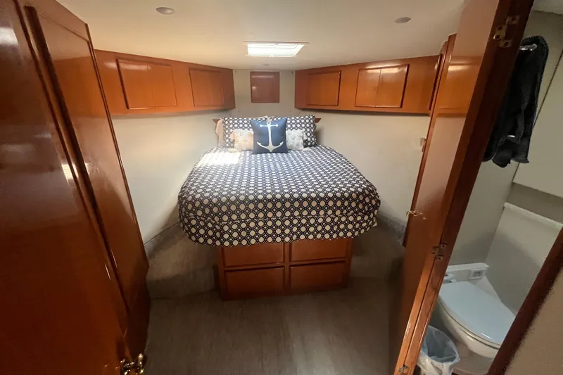 Floridita Yacht Photos Pics Cozy cabin interior of 1997 Post Sportfish boat with patterned bedding and wooden cabinets.