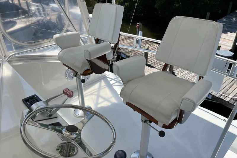 Floridita Yacht Photos Pics 1997 Post Sportfish helm with dual white captain chairs and steering wheel.