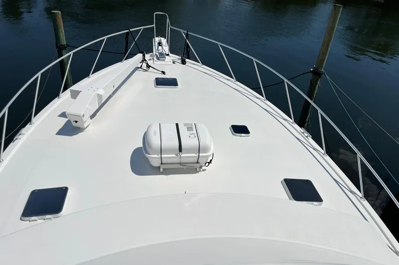 Floridita Yacht Photos Pics 1997 Post Sportfish boat deck with railing and life raft, docked on calm water.