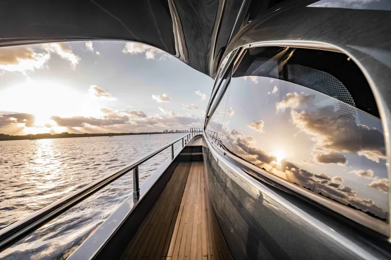  Yacht Photos Pics 2017 Pershing 70 yacht reflecting sunset on water, showcasing sleek design and luxury.