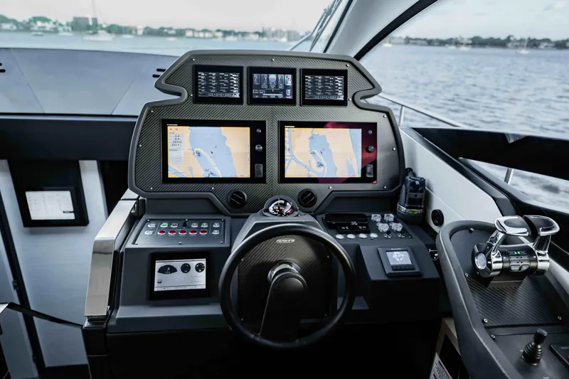  Yacht Photos Pics Cockpit of 2017 Pershing 70 yacht with navigation screens and controls, overlooking water.