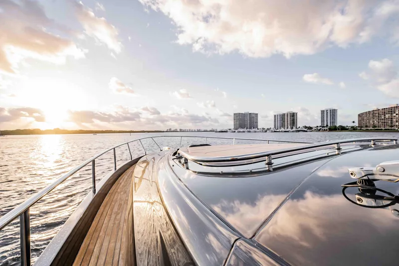  Yacht Photos Pics Luxurious 2017 Pershing 70 yacht cruising at sunset with city skyline in background.