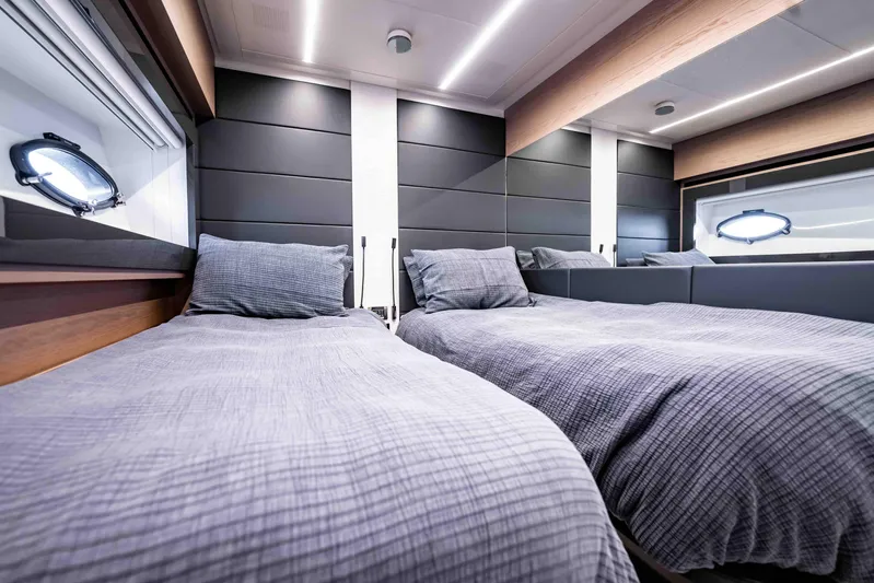  Yacht Photos Pics Luxurious twin bedroom interior on a 2017 Pershing 70 yacht, featuring modern design and porthole windows.