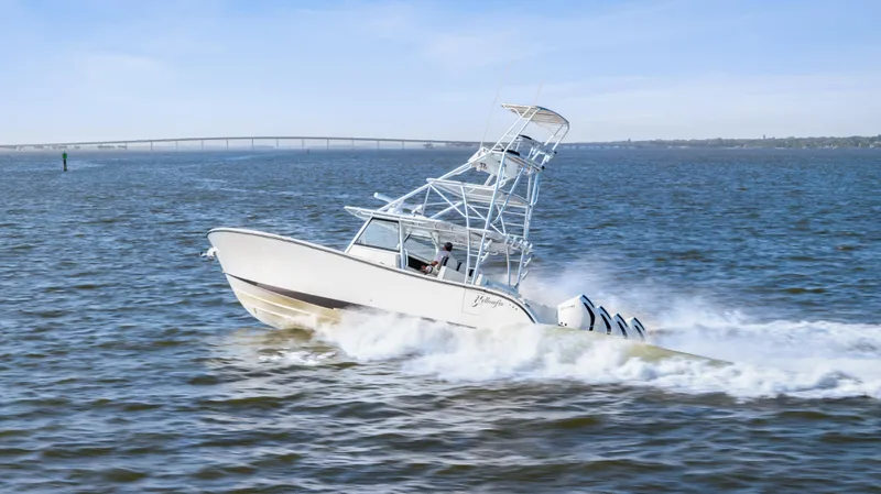  Yacht Photos Pics 2018 Yellowfin 42 Offshore boat cruising on open water with bridge in background.