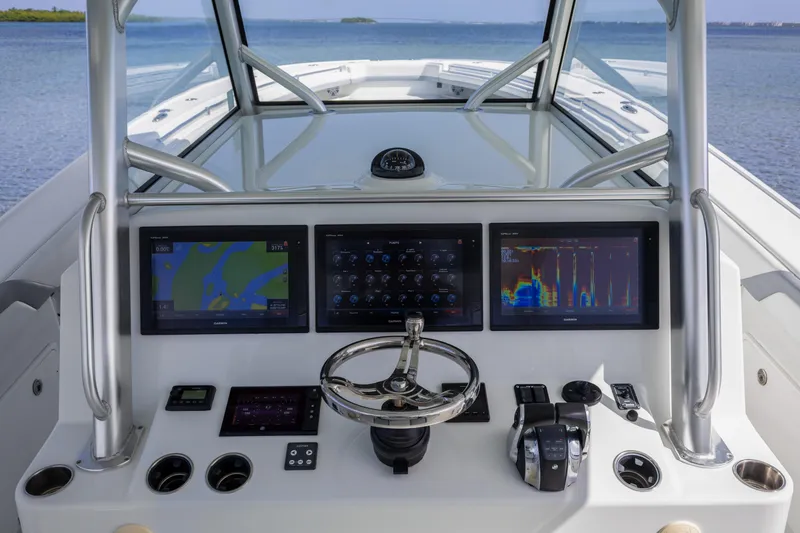  Yacht Photos Pics 2018 Yellowfin 42 Offshore boat dashboard with navigation screens and steering wheel.