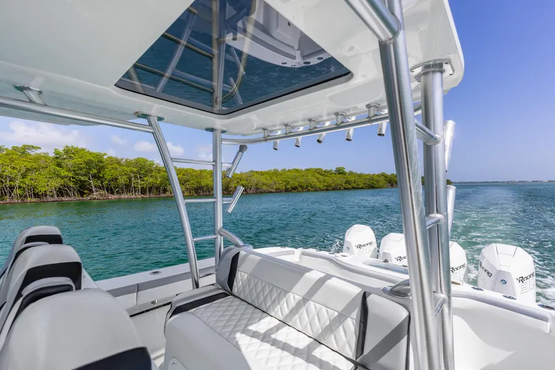  Yacht Photos Pics 2018 Yellowfin 42 Offshore boat cruising on clear waters near lush green shoreline.