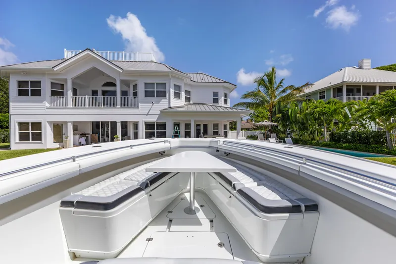  Yacht Photos Pics 2018 Yellowfin 42 Offshore boat docked near a luxurious waterfront home.