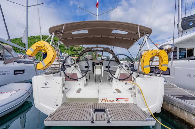 Minx Yacht Photos Pics 2024 Jeanneau Sun Odyssey 349 sailboat docked, featuring dual steering wheels and safety equipment.