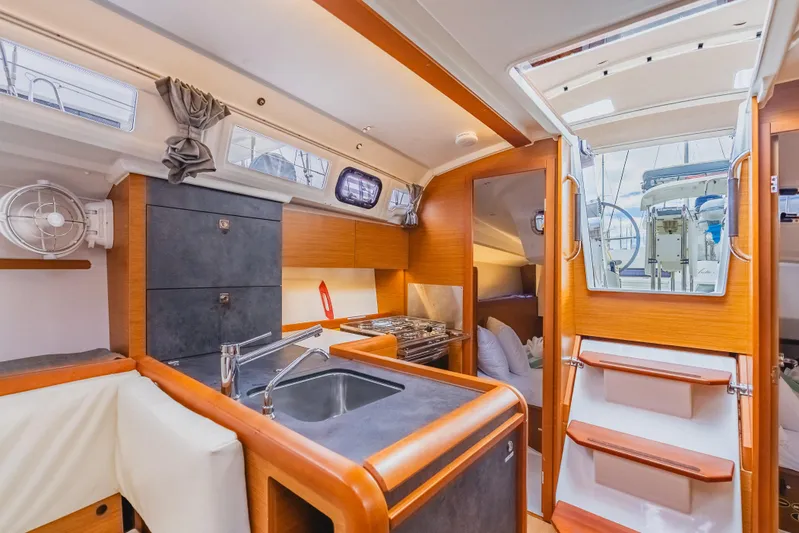 Minx Yacht Photos Pics 2024 Jeanneau Sun Odyssey 349 interior with modern kitchen and wooden finishes.